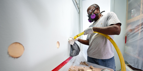 man installing wall insulation 