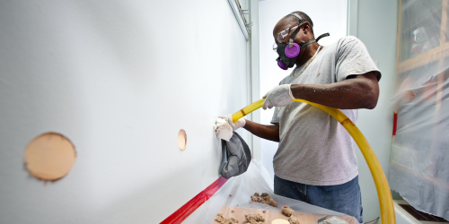 man installing wall insulation